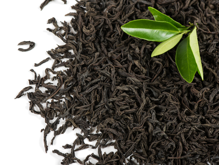 Dry black tea and green leaves isolated on white background.の写真素材