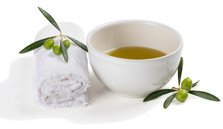 Bowl of olive oil,and towel decorated with green olive fruit isolated on white background. Hands Spa. Manicure concept.の写真素材