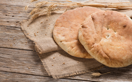 Two homemade pita bread decorated with ears on a old wooden table.の写真素材