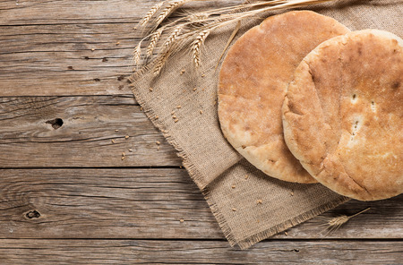 Top view of two homemade pita bread decorated with ears on a old wooden table with copy space.の写真素材