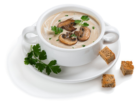 Mushroom cream soup decorated with sliced champignons, parsley and croutons in a white ceramic bowl. Isolated on white background.の写真素材