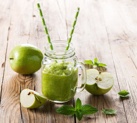 Apple puree with mint in a jar mug on a rustic wooden background with copy space.の写真素材