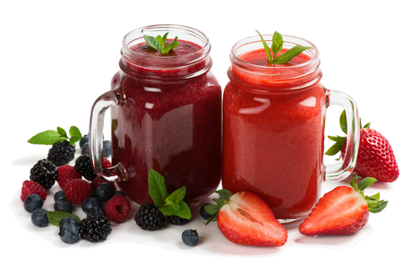 Two colorful smoothies of summer berries ( strawberry, blueberry, raspberry and blackberry ) decorated with mint isolated on white background.の写真素材