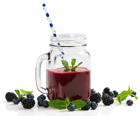 Smoothie of summer berries ( blueberry and blackberry ) in mason jars with straws isolated on white background.の写真素材