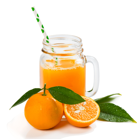 Orange fruits with green leaves and freshly squeezed orange juice in a mason jar isolated on white background.の写真素材