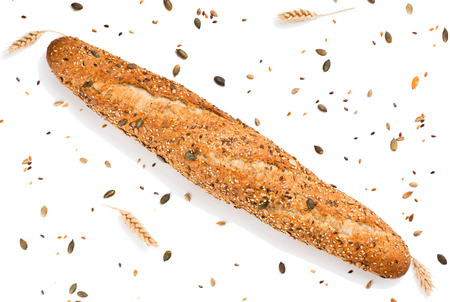 Top view of baguette topped with different seeds, such as pumpkin, flax, sunflower, sesame, millet and  poppyseeds decorated with wheat ears isolated on white background. の写真素材