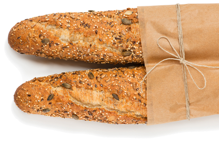 Top view of two baguettes baked bread in paper with different seeds ( pumpkin, poppy, flax, sunflower, sesame, millet ) isolated on white background. の写真素材
