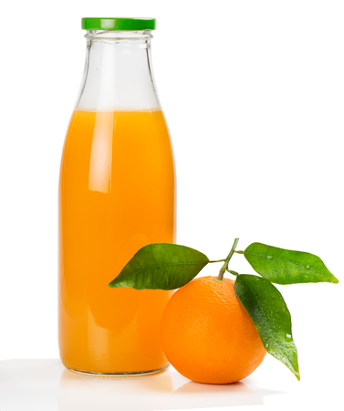 Orange juice in a glass bottle and orange fruit with green leaves isolated on white background.の写真素材