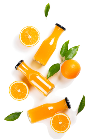 Top view of bottles of orange juice and orange fruits with green leaves isolated on white background.の写真素材
