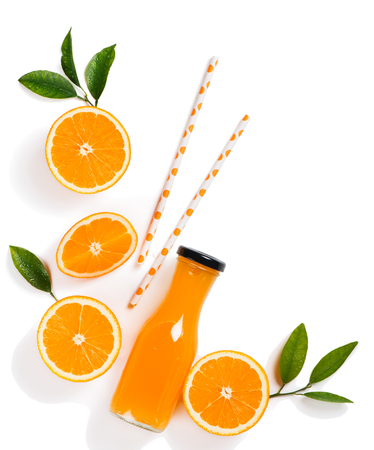 Top view of freshly squeezed orange juice in a glass bottle,drinking straws and orange slice with green leaves isolated on white background.の写真素材