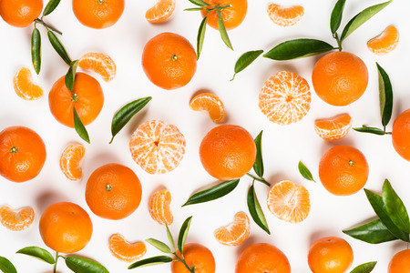 Background made from leaves, slices, halves and wholes tangerines. Top view.の写真素材