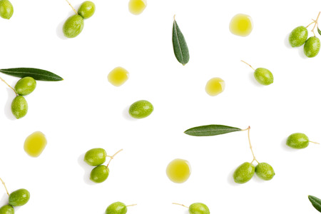 Top view of fresh green olive fruits with leaves and puddles of olive oil isolated on white background.の写真素材