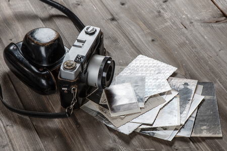 Old camera and photographs on a rustic wooden background with copy space.の写真素材