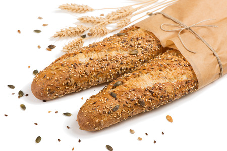 Breads in paper with different seeds ( pumpkin, poppy, flax, sunflower, sesame, millet ) decorated with wheat ears isolated on white background.の写真素材