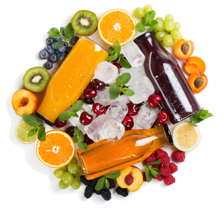Three different color wet glass bottles with juices, various fruits and berries, ice cubes isolated on white background. Top view. Summer 
concept.の写真素材