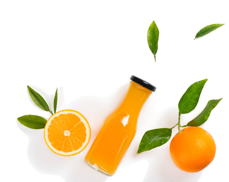 Top view of orange juice in a glass bottle, whole orange and orange slice with green leaves isolated on white background.の写真素材