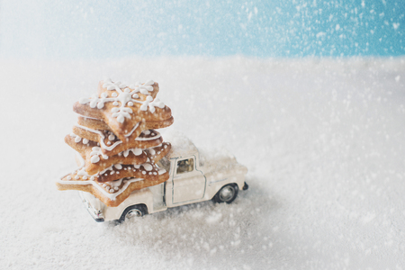 Christmas card with toy car and gingerbread like fir on snowの写真素材