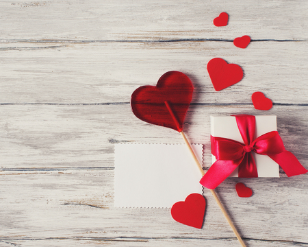 Present Gift With Red Ribbon Hearts Candy Lollipop Blank Note On Rustic Grey Backgroundの写真素材