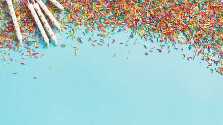 Birthday and party concept background with confetti and candels on blue, top view, copy space, bannerの写真素材
