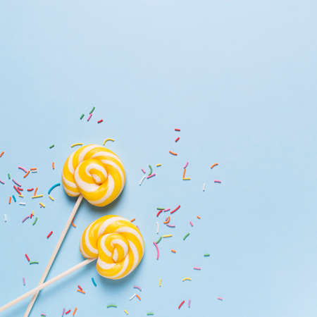 Concept of birthday and party with lollipop on blue pastel bakground, top view, copy space, squareの写真素材