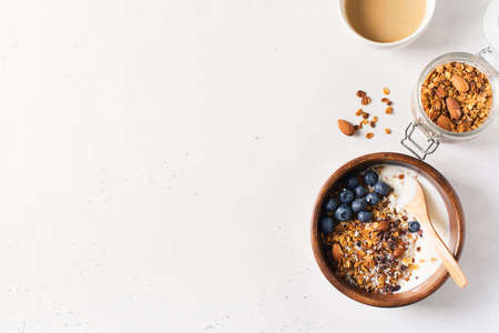 Homemade granola muesli with blueberries and coffee on white background breakfast, copy space, top...
