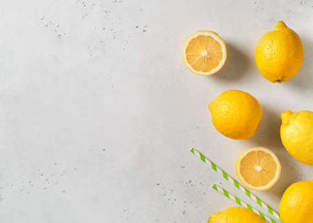 Ripe lemons frame with straw on white table background. Lemonade concept. Copy space, top viewの写真素材