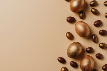 Easter concept card with golden eggs and candy sweet frame falt lay on brown background, copy space, top viewの写真素材