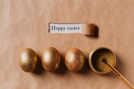 Easter concept with golden eggs and painbrush, handcraft painted flat lay on yellow backgrpund, copy space, top viewの写真素材