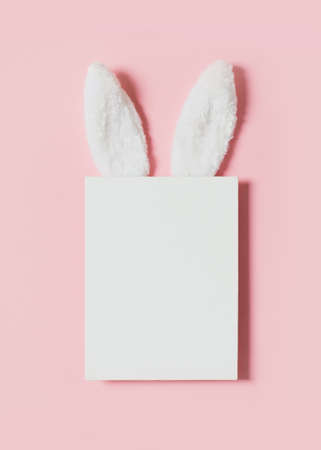 Easter mock up with rabbit poster on pink background, copy space, flat lay, top viewの写真素材