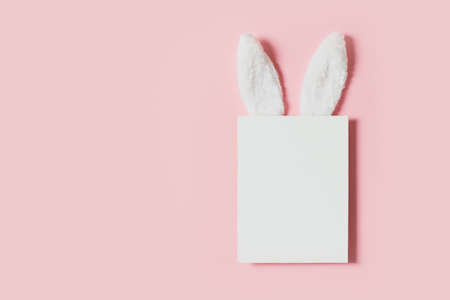 Easter mock up with rabbit poster on pink background, copy space, flat lay, top view