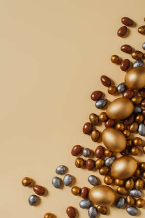 Easter concept card with golden eggs and candy sweet frame falt lay on brown background, copy space,...