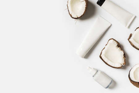 Beauty and cosmetic concept with serum bottles and coconut on white backgroundの写真素材