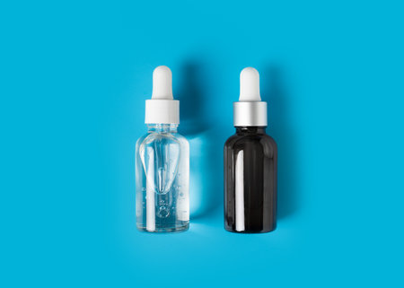 Beauty concept with bottle of serum on blue background, top view, flat layの写真素材