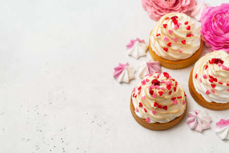 Mothers day holiday brunch with cupcake craem and pink flowers on white backgroundの写真素材