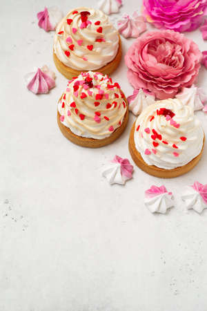 Mothers day holiday brunch with cupcake craem and pink flowers on white backgroundの写真素材