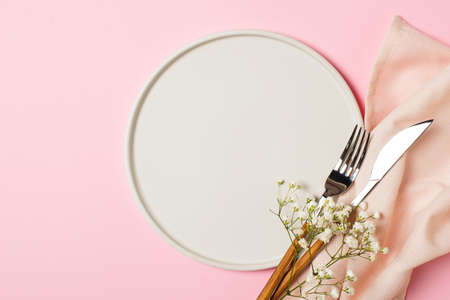 Spring and mothers day table layout with plate and tableware on pink background, flat lay, copy space, top viewの写真素材