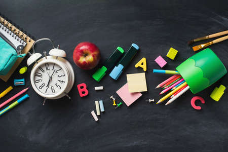 School supplies background flat lay on blackboard, back to school concept, copy space, frame