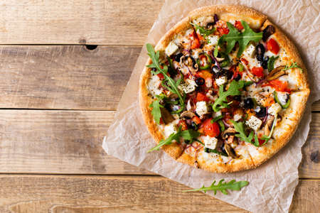 Vegetable italian pizza with tomatos on wodeen background, copy space, top view