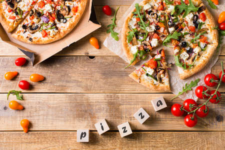 Vegetable italian pizza with tomatos on wodeen background, copy space, top viewの写真素材