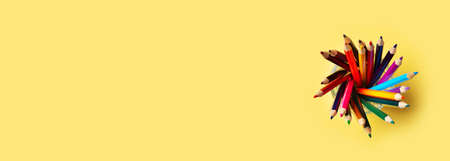 Colorful pencils above on yellow background, back to school theme