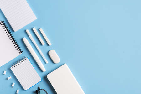 Back to school theme with papernote and white schools tools on blue background flat lay, top view, copy spaceの写真素材
