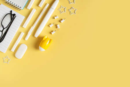 Back to school theme with white schools tools and rocket on yellow background flat lay, top view, copy spaceの写真素材