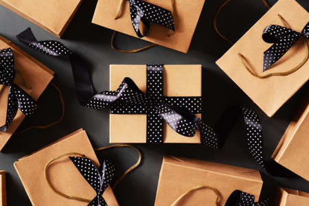 Black friday concept with craft package with black bow and ribbon, top view, copy space, flat lay