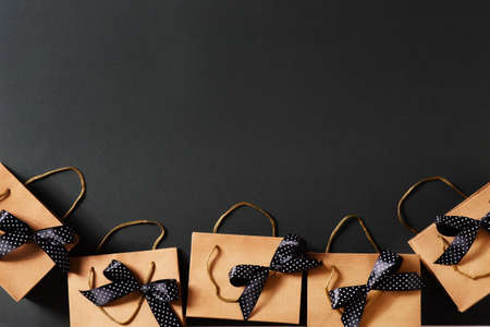 Black friday concept with craft package with black bow and ribbon, top view, copy space, flat lay