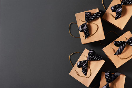 Black friday concept with craft package with black bow and ribbon, top view, copy space, flat layの写真素材
