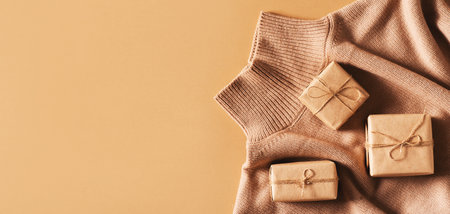 Eco friendly craft gift box with cozy sweater on brown background, top view, copy space, flat layの写真素材