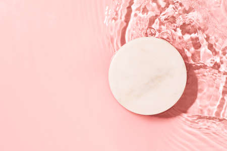 Transparent and clean pink water background with podium sunlight reflection, top view, beauty backdrop, mock upの写真素材