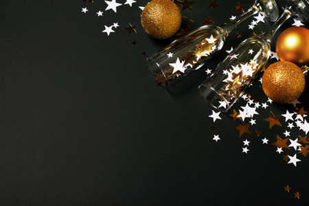 Christmas stars background with glass of champagne, gold and black glow and shine backdrop, celebration concept, verticalの写真素材