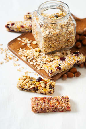 Nuts and oats energy mix bars wit jar on white background, top view, copy spaceの写真素材