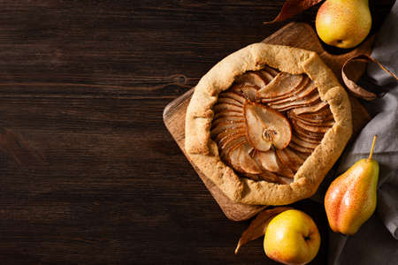 Pie or tart pear with spice on dark wooden background, top view, close upの写真素材